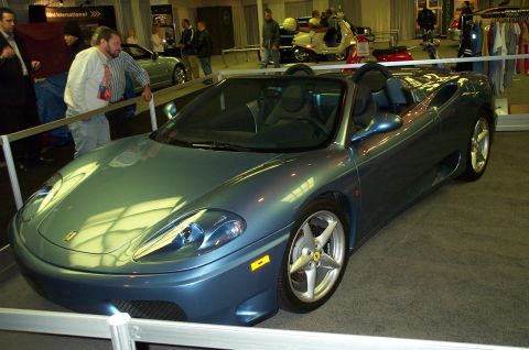 2001 Ford Crown Victoria - A blue convertible sports car is displayed indoors, likely at an auto show or dealership.