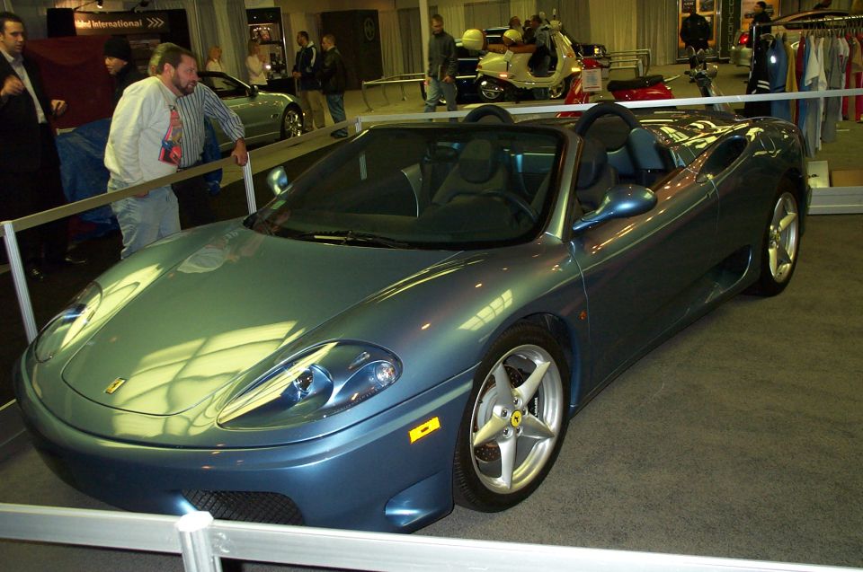 Blue convertible sports car with silver wheels and a black interior