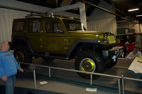 2001 Ford Crown Victoria - Olive green Jeep Wrangler with distinctive yellow accents on the wheels and grille, equipped with a roof rack.