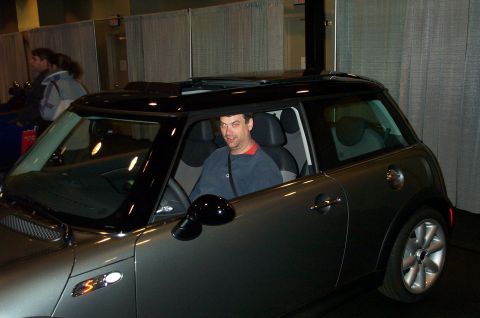 2001 Ford Crown Victoria - A man sits in the driver's seat of a gray Mini Cooper S.