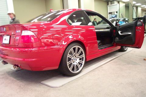 2001 Ford Crown Victoria - Red BMW M3 coupe on display, doors open to reveal interior details and custom wheels.