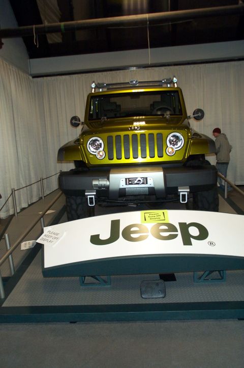 2001 Ford Crown Victoria - A yellow Jeep concept vehicle is on display, with a person standing nearby.