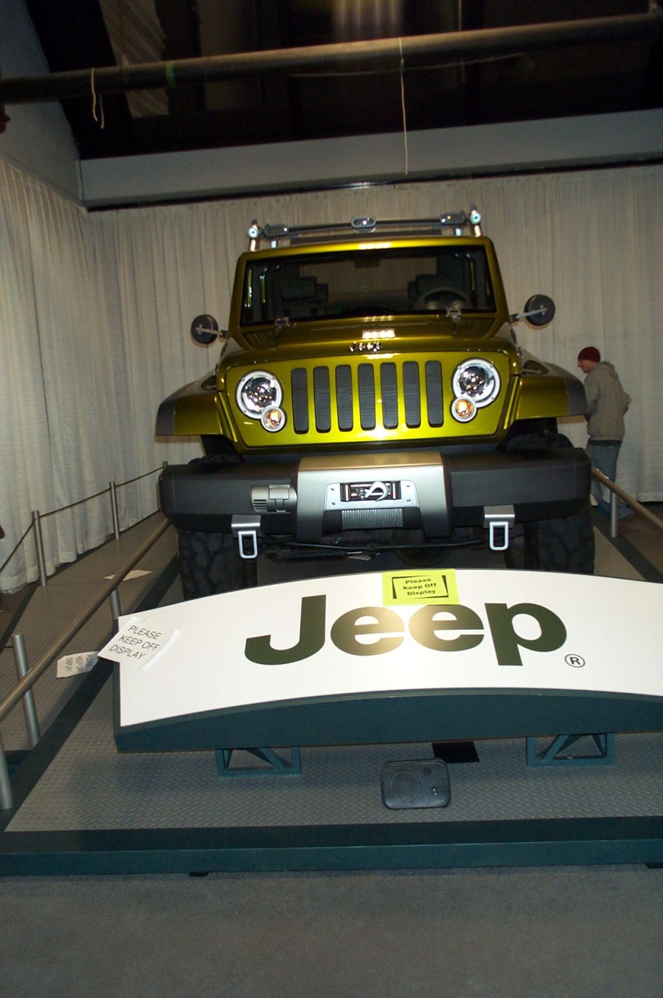 Yellow Jeep concept vehicle on display with 'Jeep' logo in foreground
