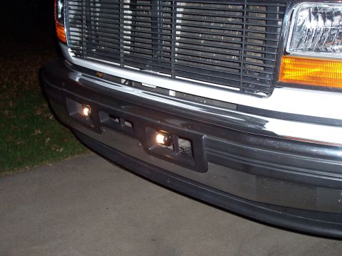 1994 Ford Bronco - Close-up of a vehicle's front end, showing the bumper, grille, and fog lights.