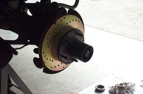 1995 Ford Bronco - Close-up view of a vehicle's front brake rotor and hub assembly, drilled holes for improved cooling.