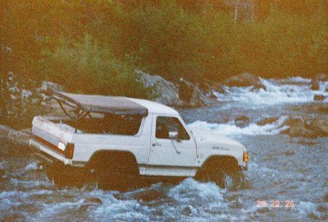 1994 Ford Bronco - White Ford Bronco navigates a river crossing, showing its off-road capability.