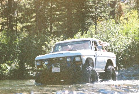 1994 Ford Bronco - This lifted 1978 Ford F-150 navigates a shallow stream, its large tires kicking up water.