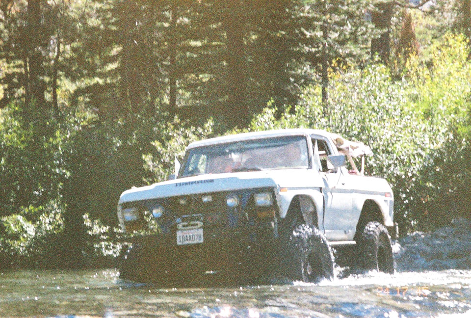 1978 Ford F-150 driving through water, lifted with large tires