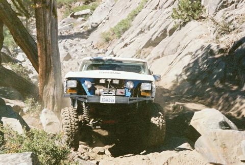 1994 Ford Bronco - This modified truck navigates a challenging rocky trail, kicking up dust.