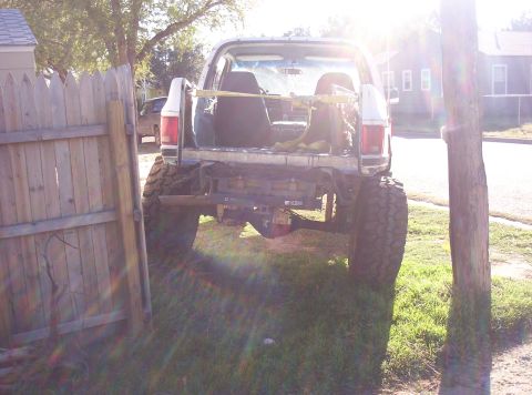 1988 Ford Bronco - Rear view of a modified white Ford Bronco with lifted suspension and large tires, parked outdoors.