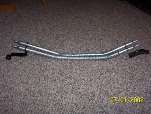2003 Ford Taurus - A part, possibly a fuel line or vacuum hose assembly, is shown on a carpeted surface.