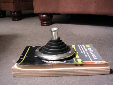 2003 Chevrolet Monte Carlo - A car shifter boot and knob rest on a Haynes repair manual for VW Golf and Jetta, placed on a stack of books.