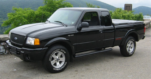 Black 2002 Ford Ranger pickup truck with a tonneau cover, parked on a scenic overlook