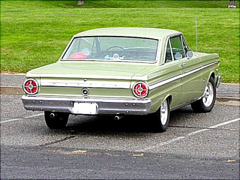 1967 Ford Ranchero - Rear view of a light green 1967 Ford Ranchero parked in a lot, showing its distinctive taillights and chrome bumper.