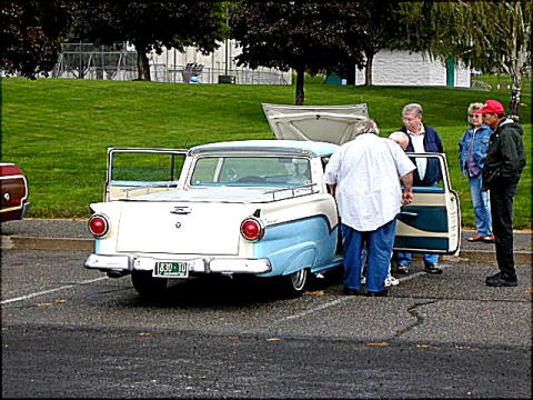 1967 Ford Ranchero - Two-tone 1957 Ford Fairlane with open doors and hood, surrounded by onlookers.