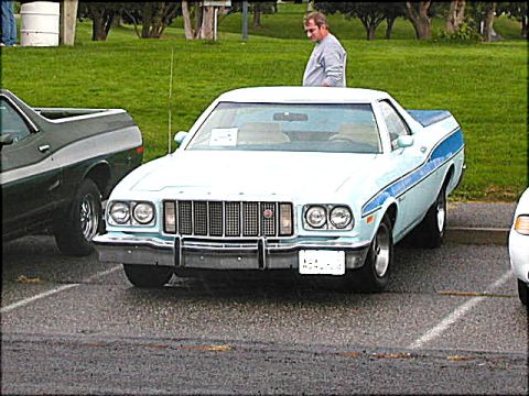 1967 Ford Ranchero - This light blue and white Ranchero features prominent blue side stripes and a distinctive grille. The vehicle appears to be a 1977 model.