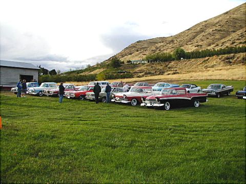 1967 Ford Ranchero - A gathering of vintage automobiles are displayed on a grassy field under a cloudy sky.