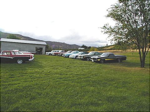 1967 Ford Ranchero - A collection of classic vehicles, including a 1967 Ford Ranchero, are parked on a lawn in front of a barn.