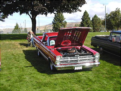 1967 Ford Ranchero - A red 1966 Ford Ranchero is displayed with its hood open, parked on a grassy field next to another vehicle.