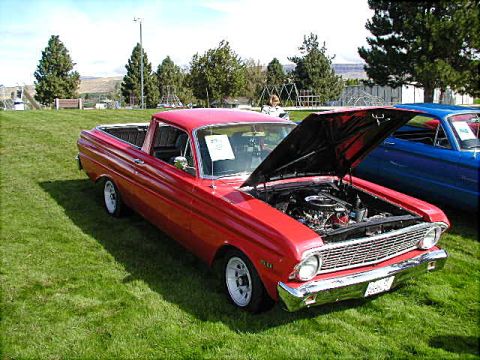 1967 Ford Ranchero - A red 1965 Ford Falcon Ranchero is displayed with its hood open, parked next to a blue car on a sunny day.