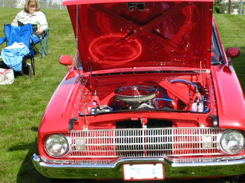 1967 Ford Ranchero - A red 1967 Ford Ranchero is displayed with its hood open, revealing the engine bay.