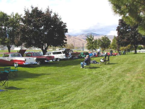 1967 Ford Ranchero - A gathering of vintage vehicles on a sunny day with people relaxing on the lawn.