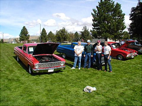 1967 Ford Ranchero - A red 1967 Ford Ranchero is displayed with its hood open, accompanied by four men at an outdoor event.