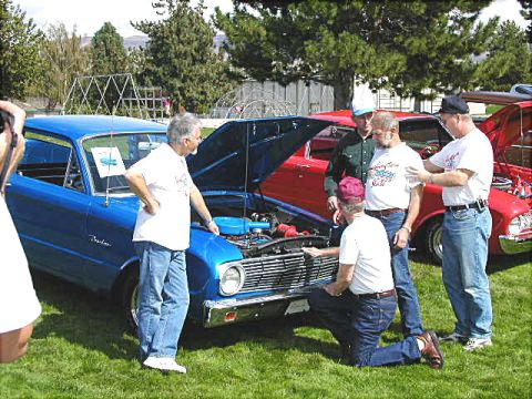 1967 Ford Ranchero - Several men examine the engine of a blue 1966 Ford Falcon Ranchero at an outdoor car show.