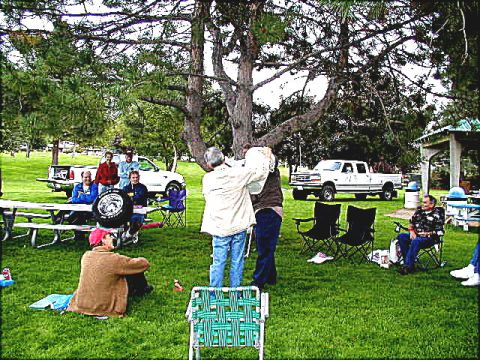 1967 Ford Ranchero - A group of people are enjoying an outdoor gathering with multiple vehicles present in the background.