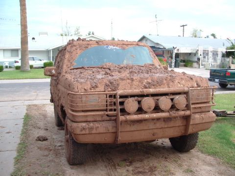 1990 Ford Bronco - This 1990 Ford Bronco is heavily covered in mud, obscuring much of its original appearance but retaining its distinctive front grille and l…