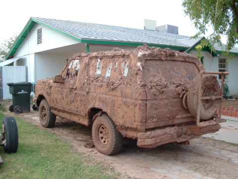 1990 Ford Bronco - This SUV is heavily covered in mud, obscuring its make and model details.