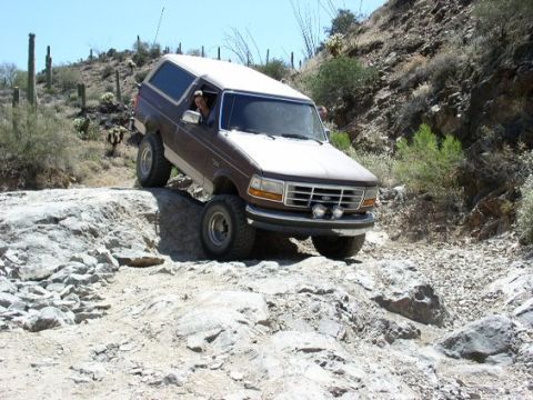 1993 Ford Bronco - This 1993 Ford Bronco navigates a challenging off-road trail with steep inclines and rocky obstacles.