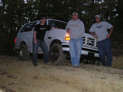 1996 Ford Bronco - Three men pose with a white Ford Bronco on a dirt trail surrounded by trees.