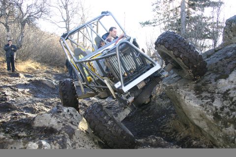 2003 Jeep TJ - Custom off-road buggy navigates a challenging rocky terrain with steep inclines.