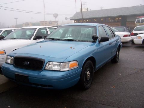 2001 Ford Crown Victoria - A blue 2001 Ford Crown Victoria is parked in a lot with other vehicles visible.