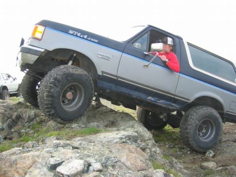 1989 Ford Bronco - This lifted 1989 Ford Bronco navigates a rocky trail, its off-road capabilities.