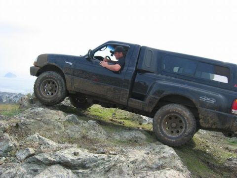 1989 Ford Bronco - This black Ford Ranger navigates a rocky trail, its off-road capabilities.