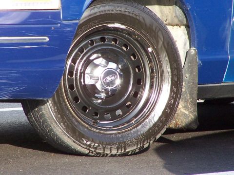 1998 Ford Crown Victoria - Close-up of a blue 1998 Ford Crown Victoria's wheel, the Ford logo on the hubcap.