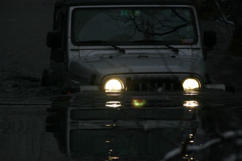 2003 Jeep TJ - A Jeep Wrangler navigates through murky water, its headlights cutting through the dim light.