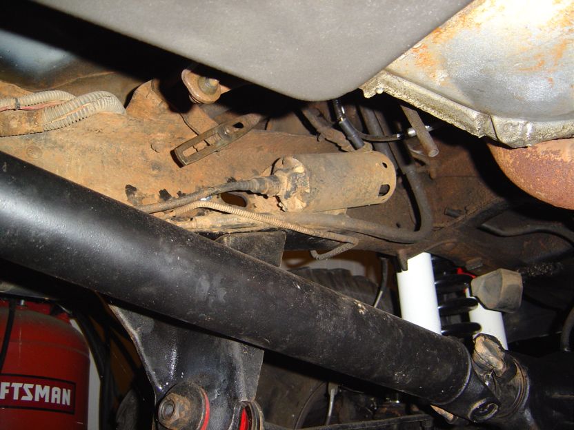 Underbody view of rusty fuel tank, fuel lines and exhaust on a lifted truck frame