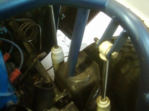 1978 Ford Bronco - Close-up view of a blue roll cage and suspension components within a vehicle's interior.
