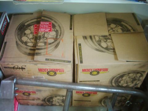 1978 Ford Bronco - Several boxes containing Mickey Thompson wheels are stacked, with a metal bar in the foreground.