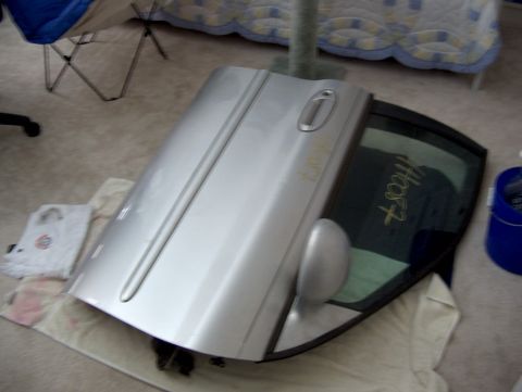 1998 Ford Taurus - A detached car door and window are shown on the floor, with writing on the glass.