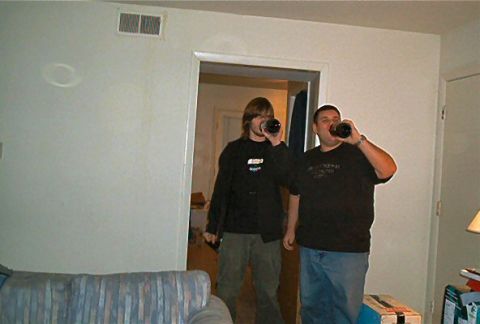 1985 Ford LTD Crown Victoria - Two men are drinking from bottles in a room.