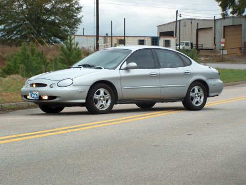 1998 Ford Taurus - Silver 1998 Ford Taurus sedan seen from the side on a paved road.