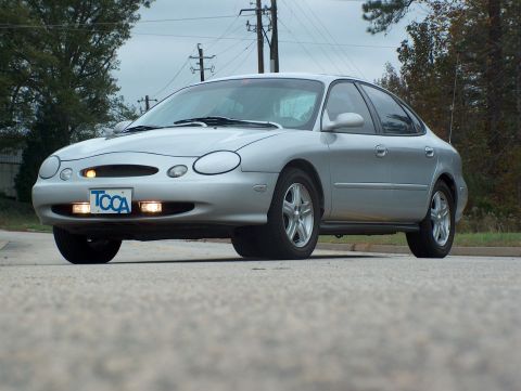 1998 Ford Taurus - A silver 1998 Ford Taurus is shown from the front-right angle, parked outdoors.