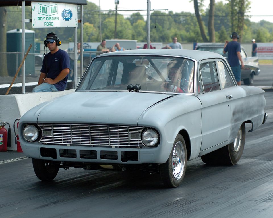 Primer gray 1960 Ford Falcon two-door drag car at the starting line of a drag strip
