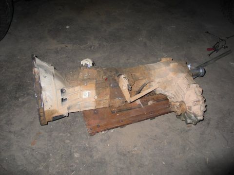 1989 Ford F-150 - Transmission assembly removed from a vehicle, resting on a wooden board.