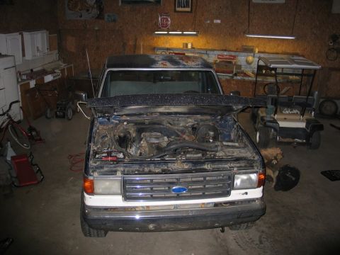 1989 Ford F-150 - Front view of a Ford F-150 truck with its hood open, parked in a garage.