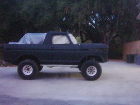1978 Ford Bronco - A 1978 Ford Bronco is parked outdoors, its bed covered and windows taped.